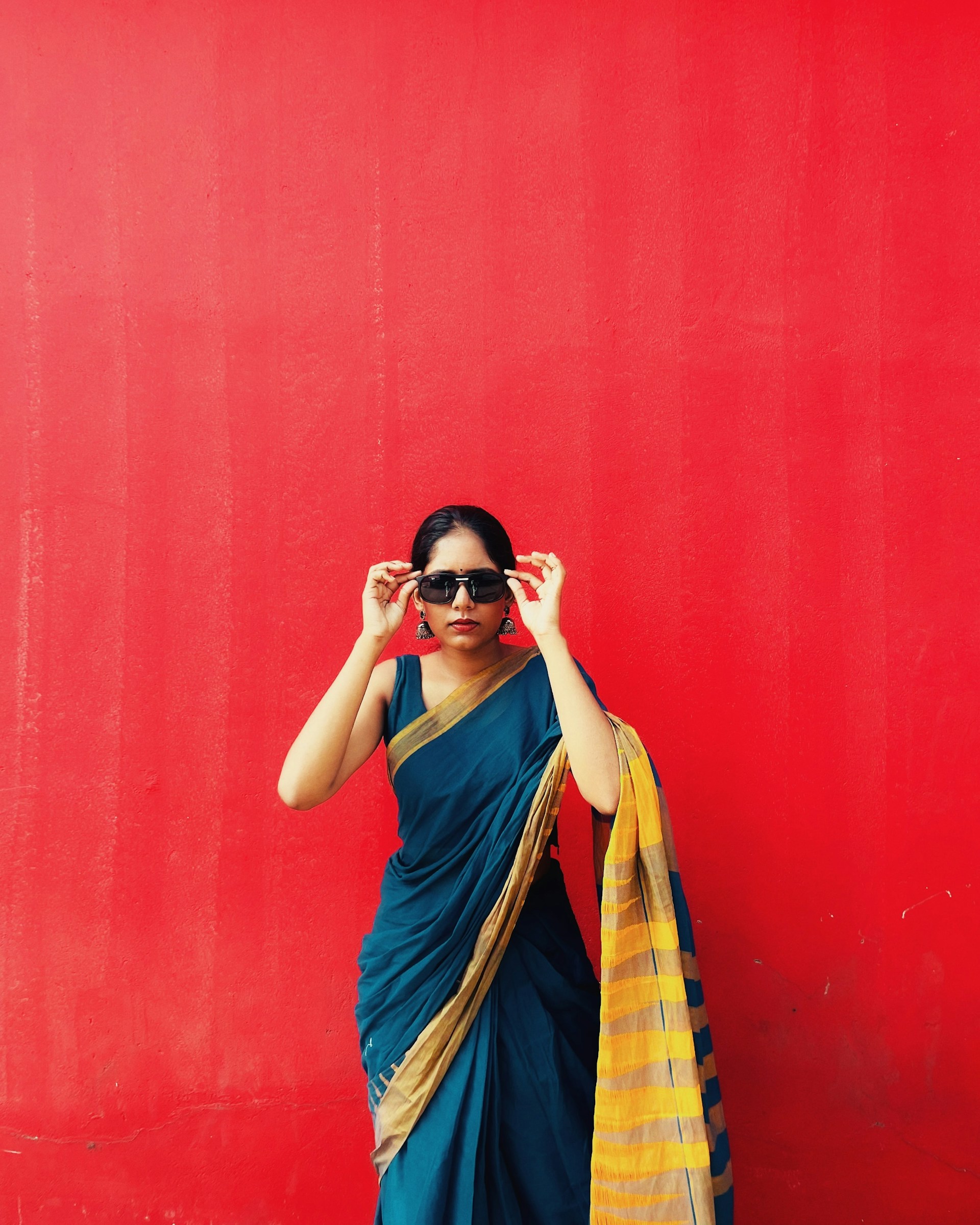 a woman wearing a blue sari and a yellow scarf