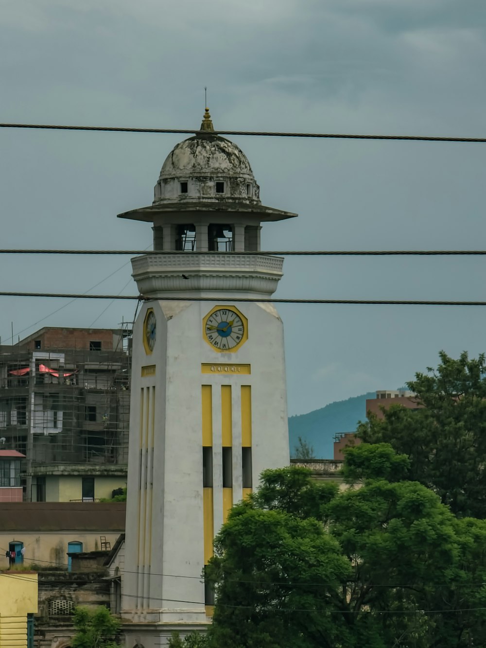 a tall white clock tower with a clock on each of it's sides