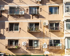 A sleek beige air conditioner cover blending with a modern balcony setting