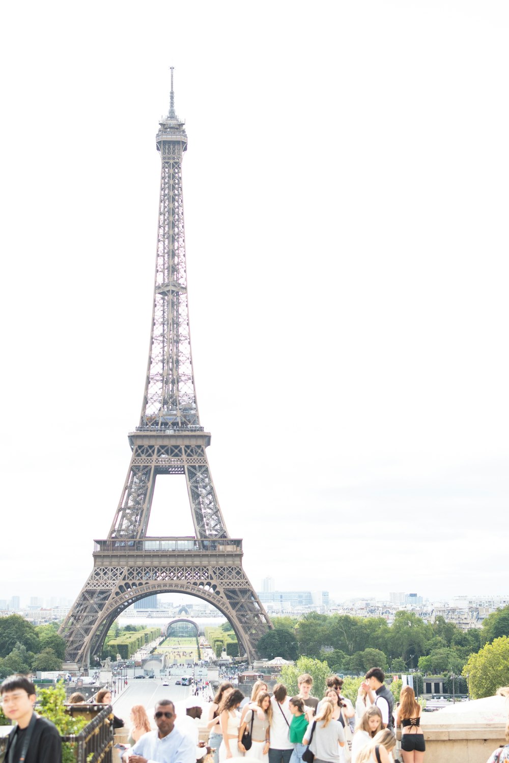 a group of people standing in front of the eiffel tower