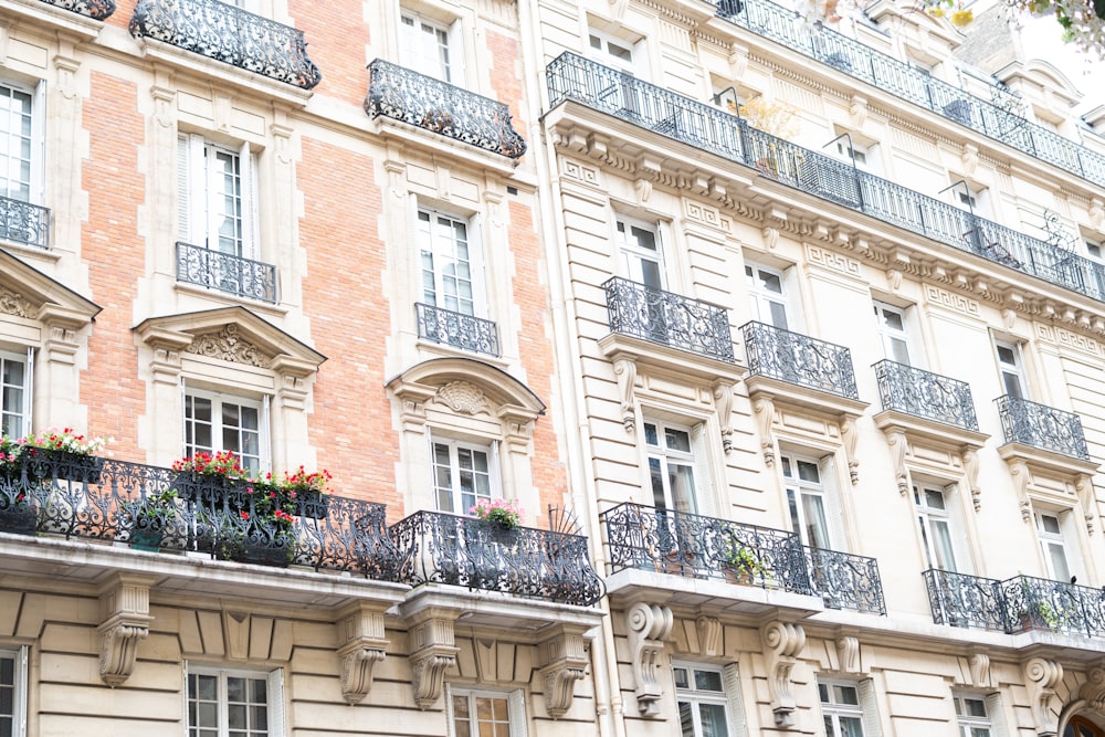 a tall building with balconies and flowers on the balconies