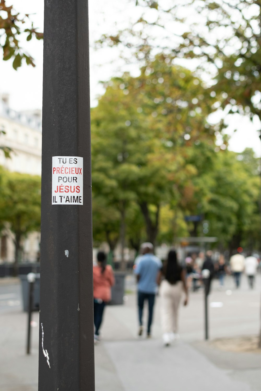 a pole with a sticker on it on a sidewalk