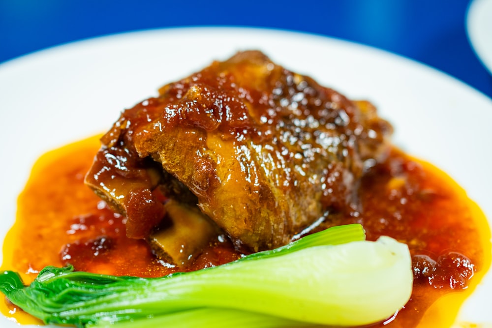 a white plate topped with meat and vegetables