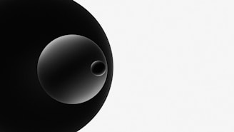 A minimalistic composition featuring a large black circle overlapping with a smaller gradient circle and an even smaller circle inside it, all set against a white background.
