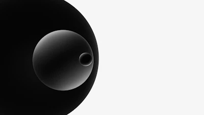 A minimalist graphic composition of overlapping circles in dark grey, red, and cyan on a black background.