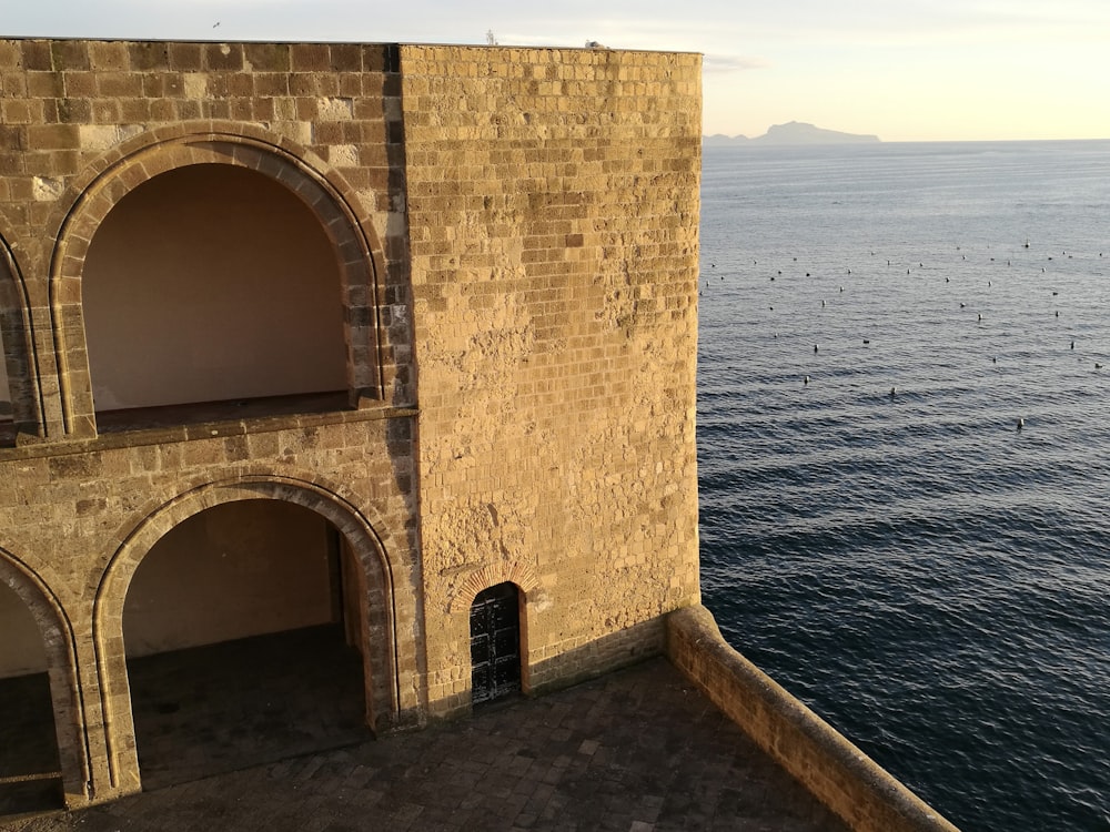 a large brick building next to a body of water