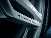 Close-up of a wheel rim of a vehicle with the word 'Corvette' inscribed on one of its spokes in a sleek, modern font.