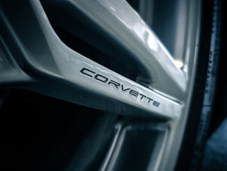 Close-up of a wheel rim of a vehicle with the word 'Corvette' inscribed on one of its spokes in a sleek, modern font.