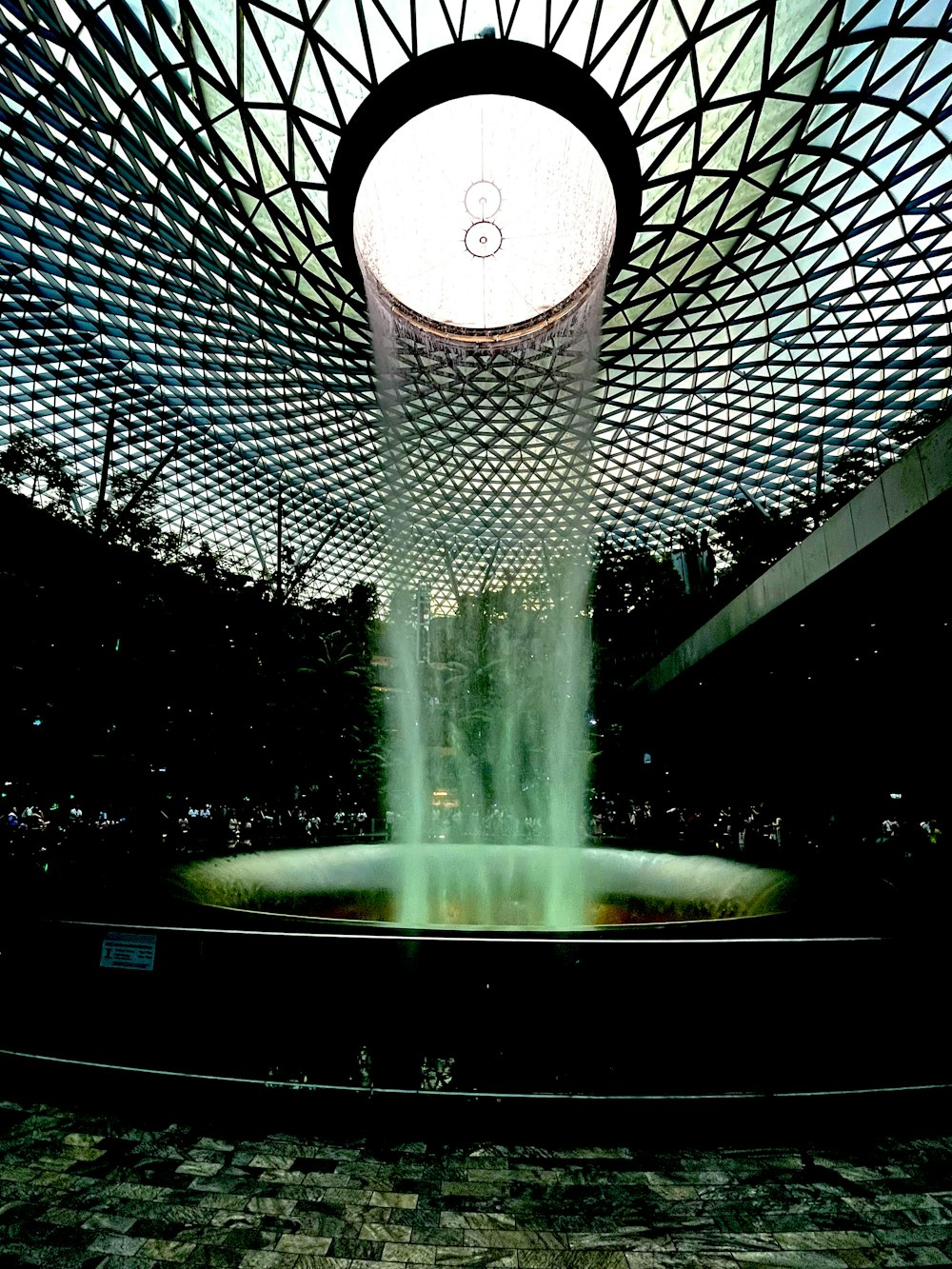 a water fountain in a building with a sky background