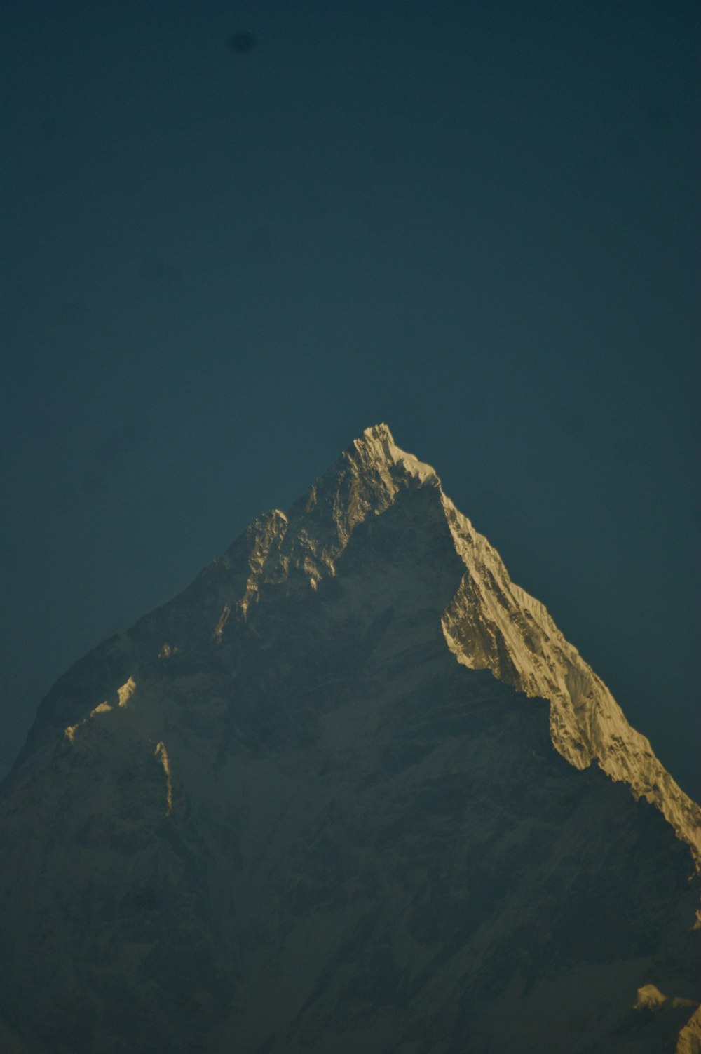 the top of a snow covered mountain at night