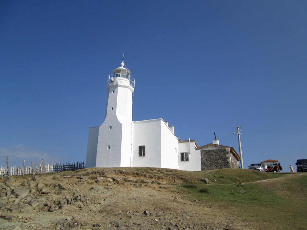 a white lighthouse on top of a hill
