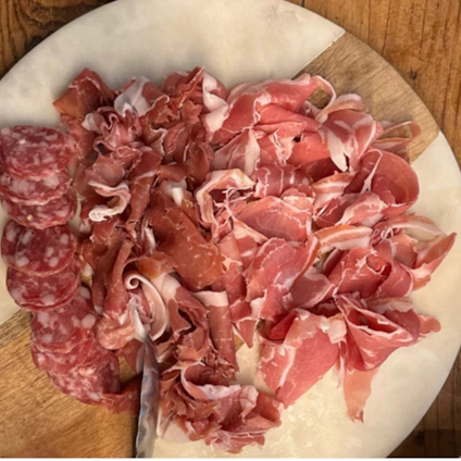 A vibrant display of assorted fresh sausages and cold cuts arranged on rustic wooden boards.