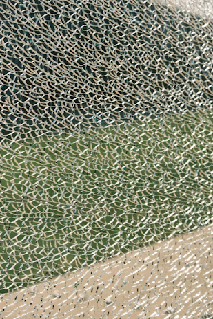Close-up of colorful broken drinking glass pieces scattered on a wooden surface