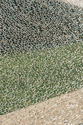 Close-up of colorful broken drinking glass pieces scattered on a wooden surface