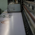 a close up of a conveyor belt with a machine in the background