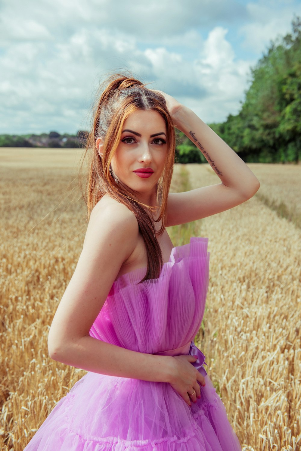 a woman in a purple dress standing in a field