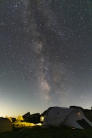 A local guide from Incaland Ventures warmly greeting travelers at a rustic campsite under starry skies.