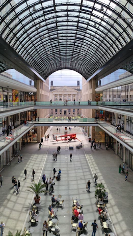 A vibrant, multi-level pet mall bustling with happy pets and their owners exploring shops and play areas.