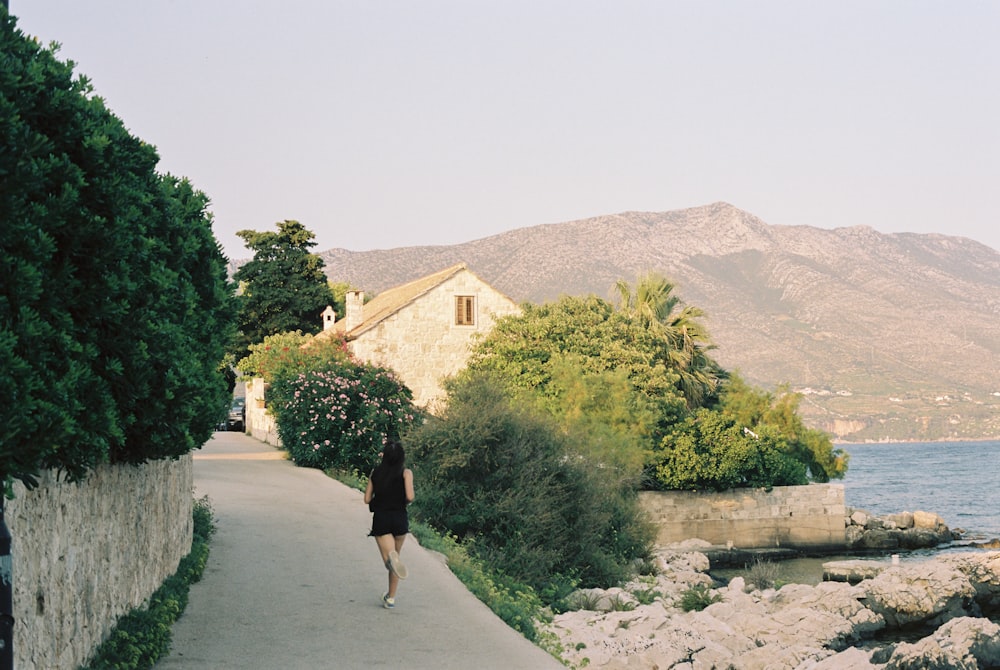 a person walking down a path next to a body of water