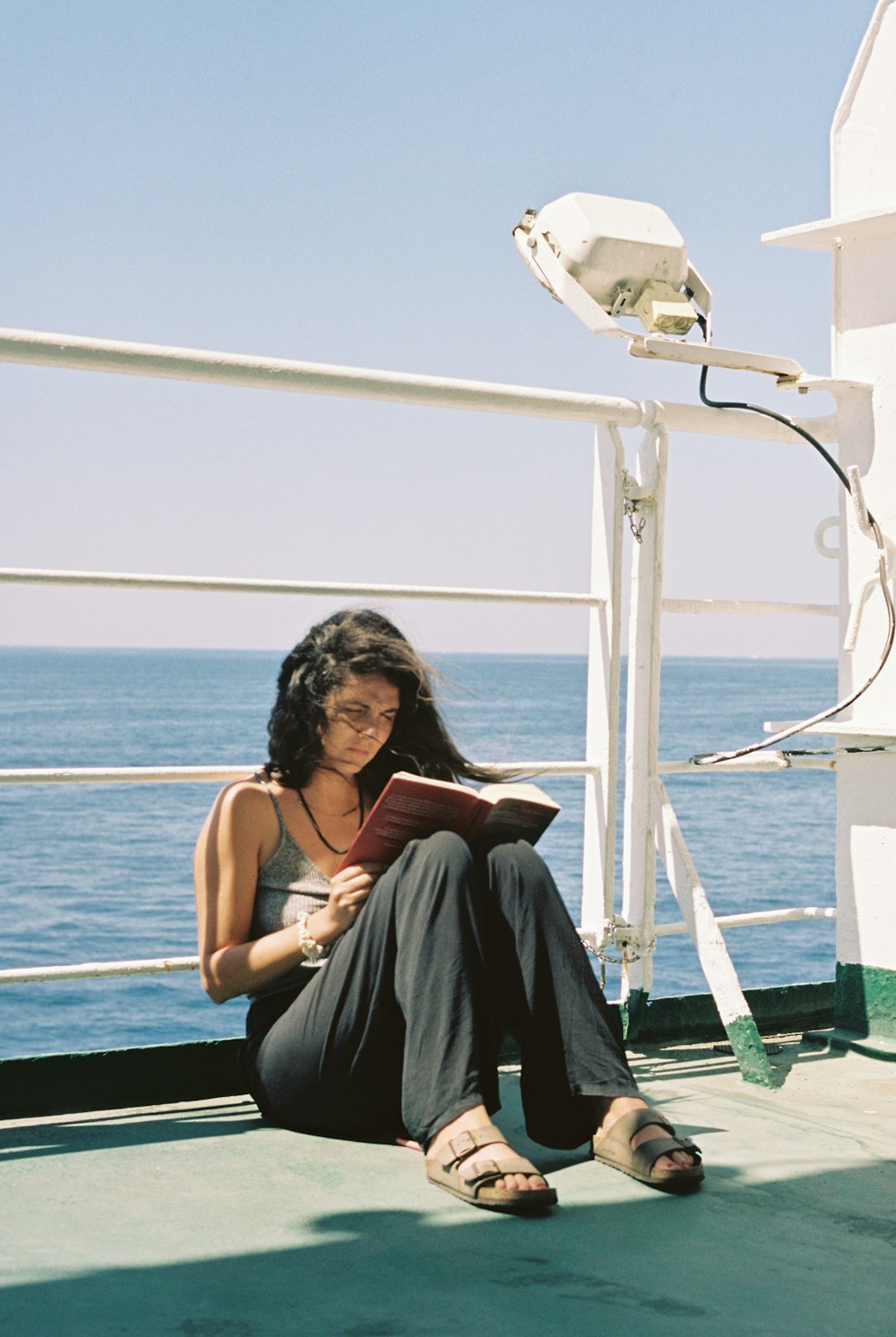 a woman sitting on a boat reading a book