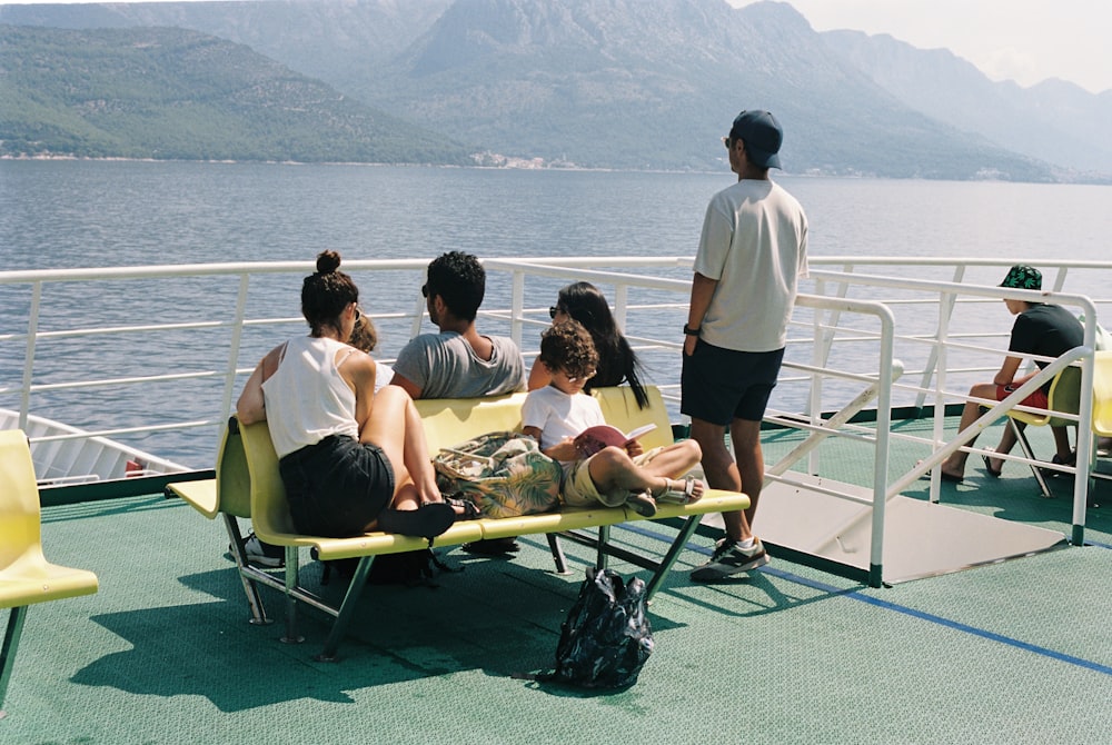 a group of people sitting on top of a yellow bench