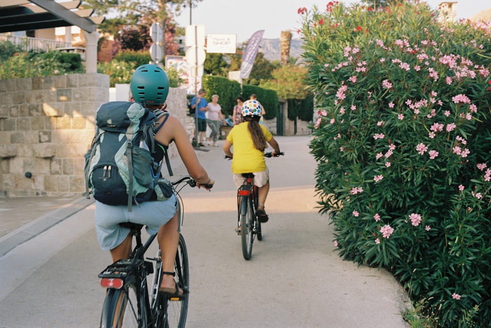 a couple of people riding bikes down a street