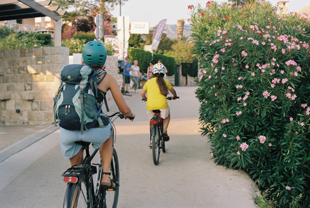a couple of people riding bikes down a street,