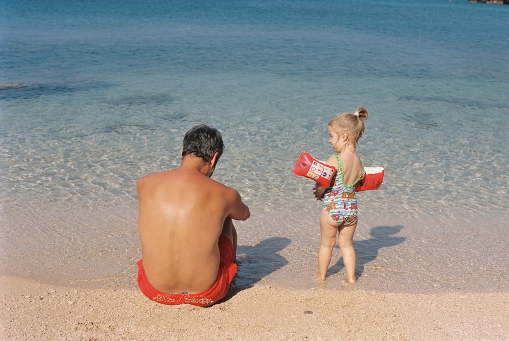 a man and a little girl on the beach