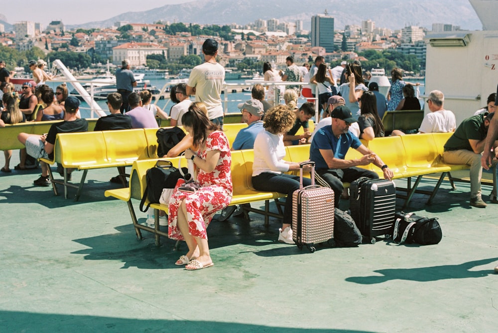 a group of people sitting on top of a yellow bench