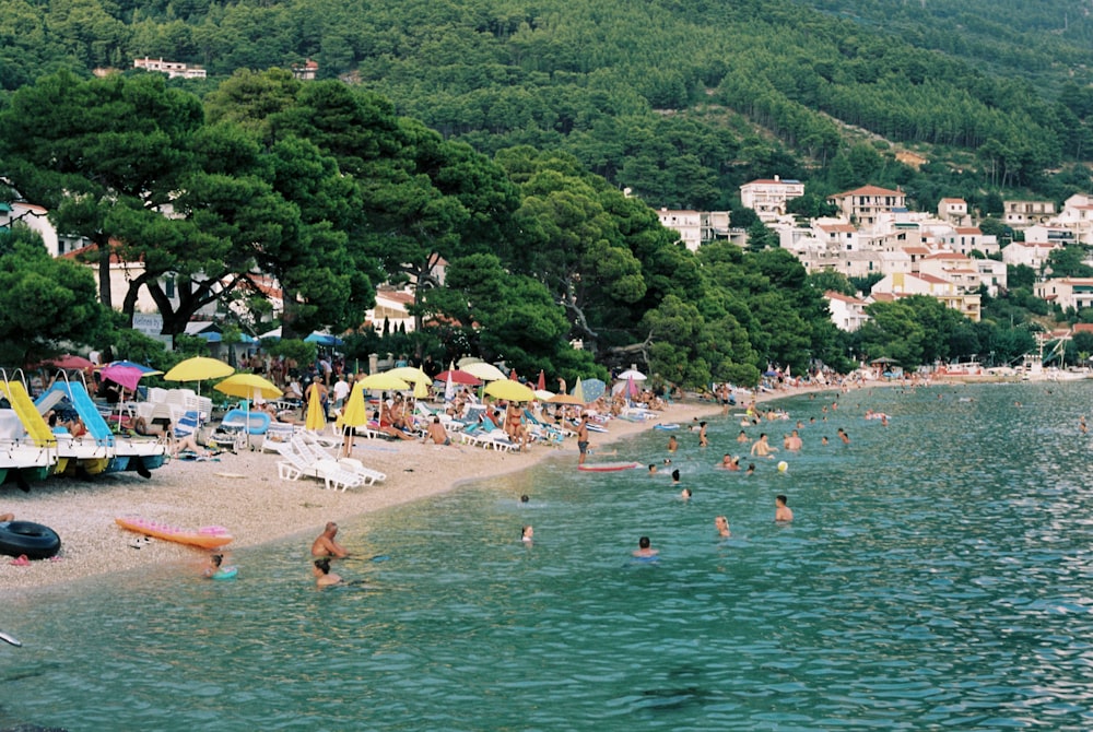 a crowded beach with lots of people and umbrellas