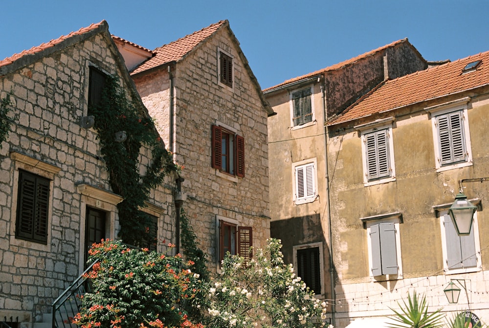 a stone building with white shutters and windows