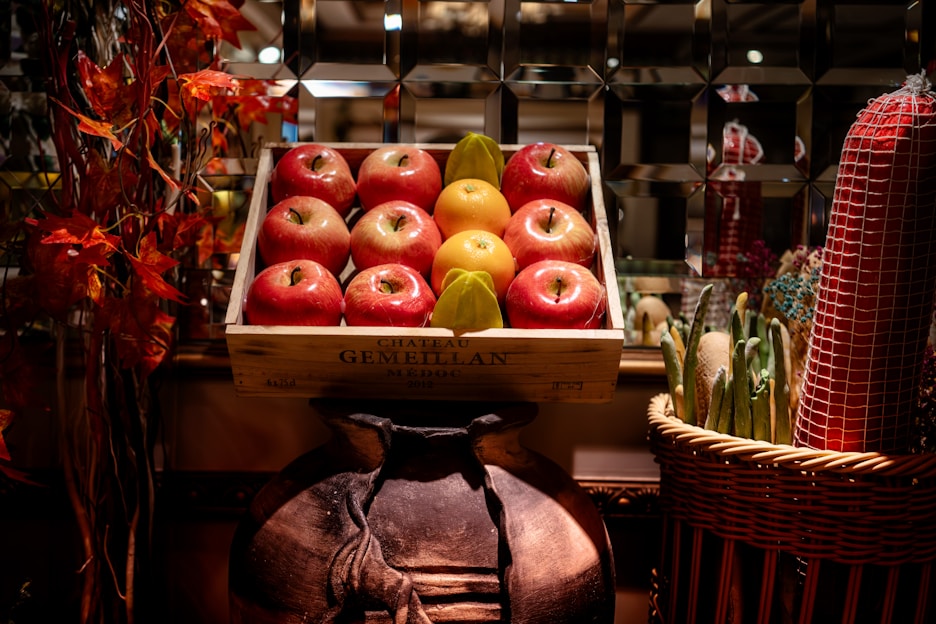 A vibrant crate overflowing with freshly picked apples and pears on a rustic wooden table.