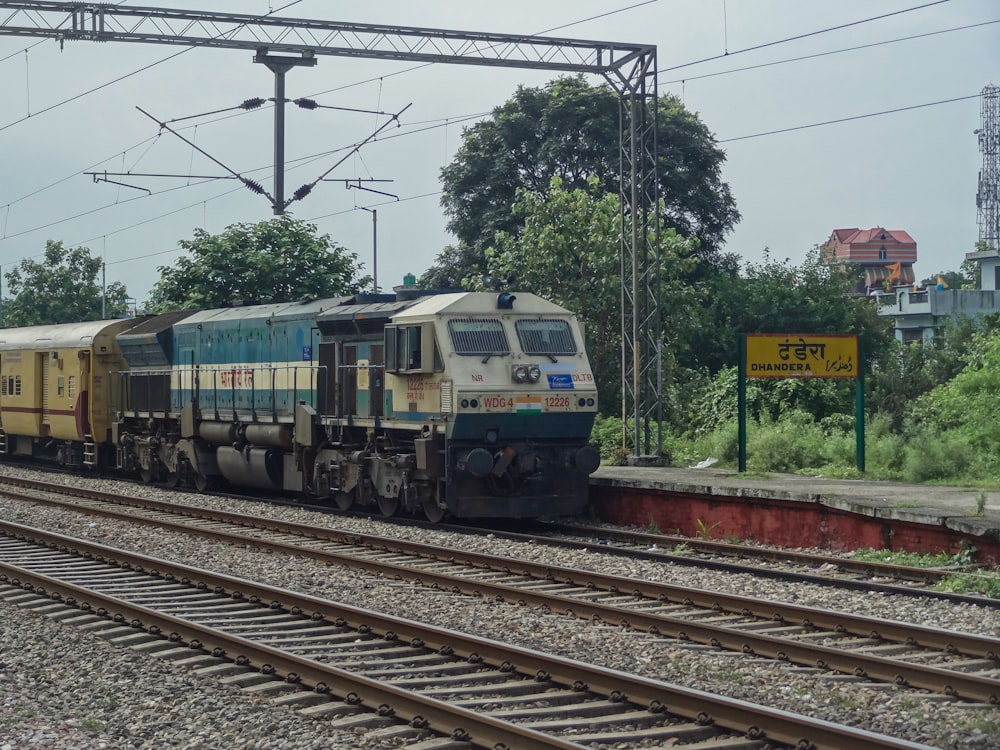 a train traveling down train tracks next to a forest