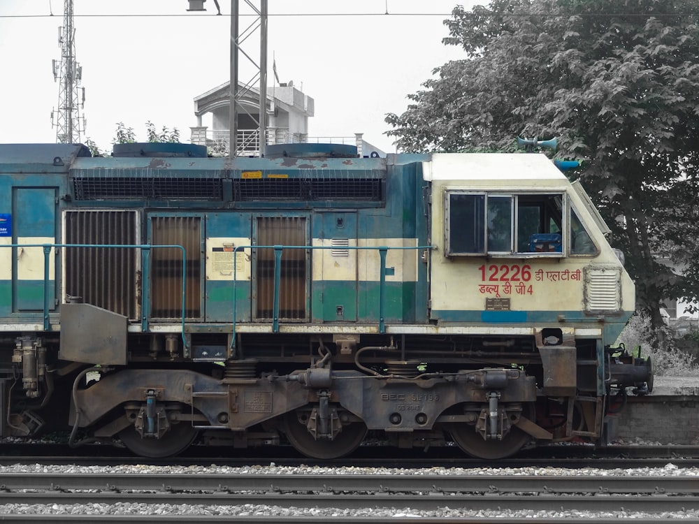 a blue and white train traveling down train tracks