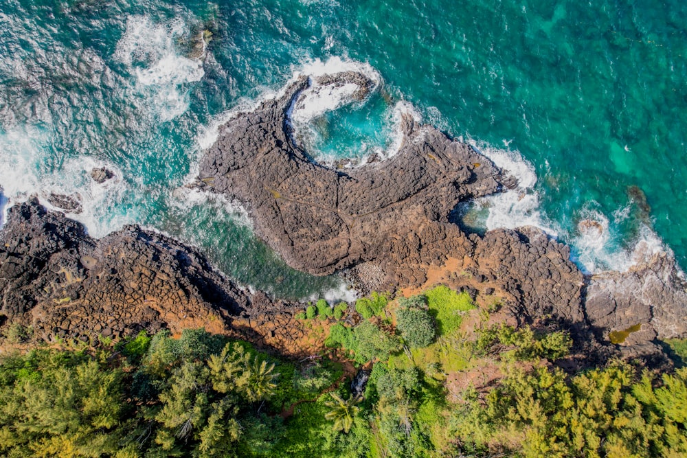 an aerial view of the ocean and rocks