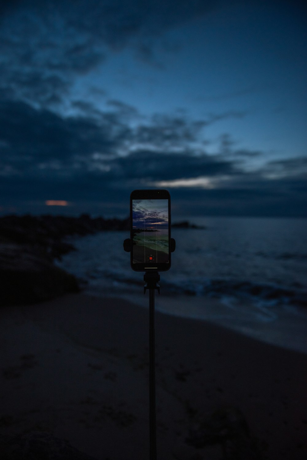 a cell phone sitting on top of a metal pole