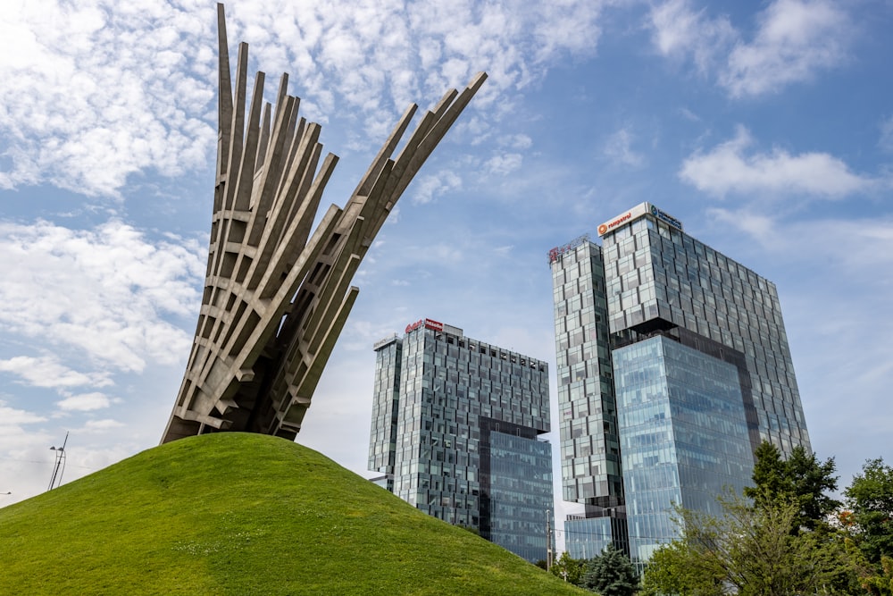 a statue of a giant bird on top of a green hill