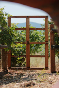 a wooden gate with a mountain in the background