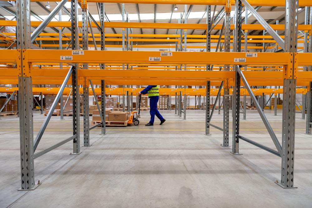 a man walking through a warehouse filled with lots of shelves