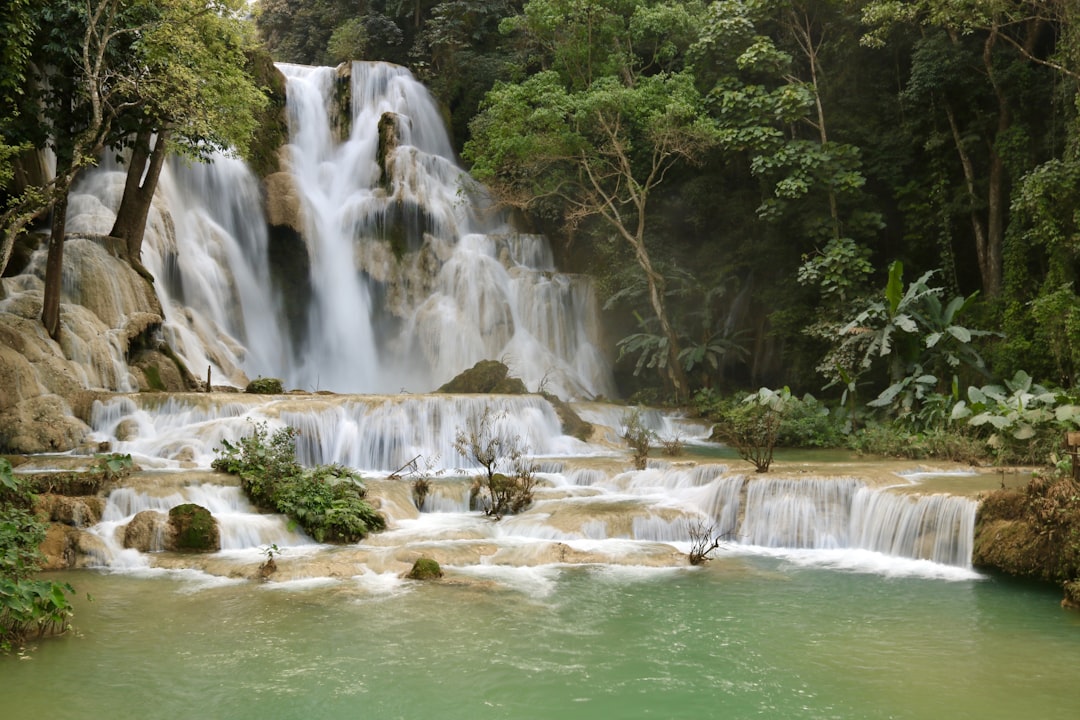 a large waterfall in the middle of a forest, Kuang Si waterfalls🇱🇦