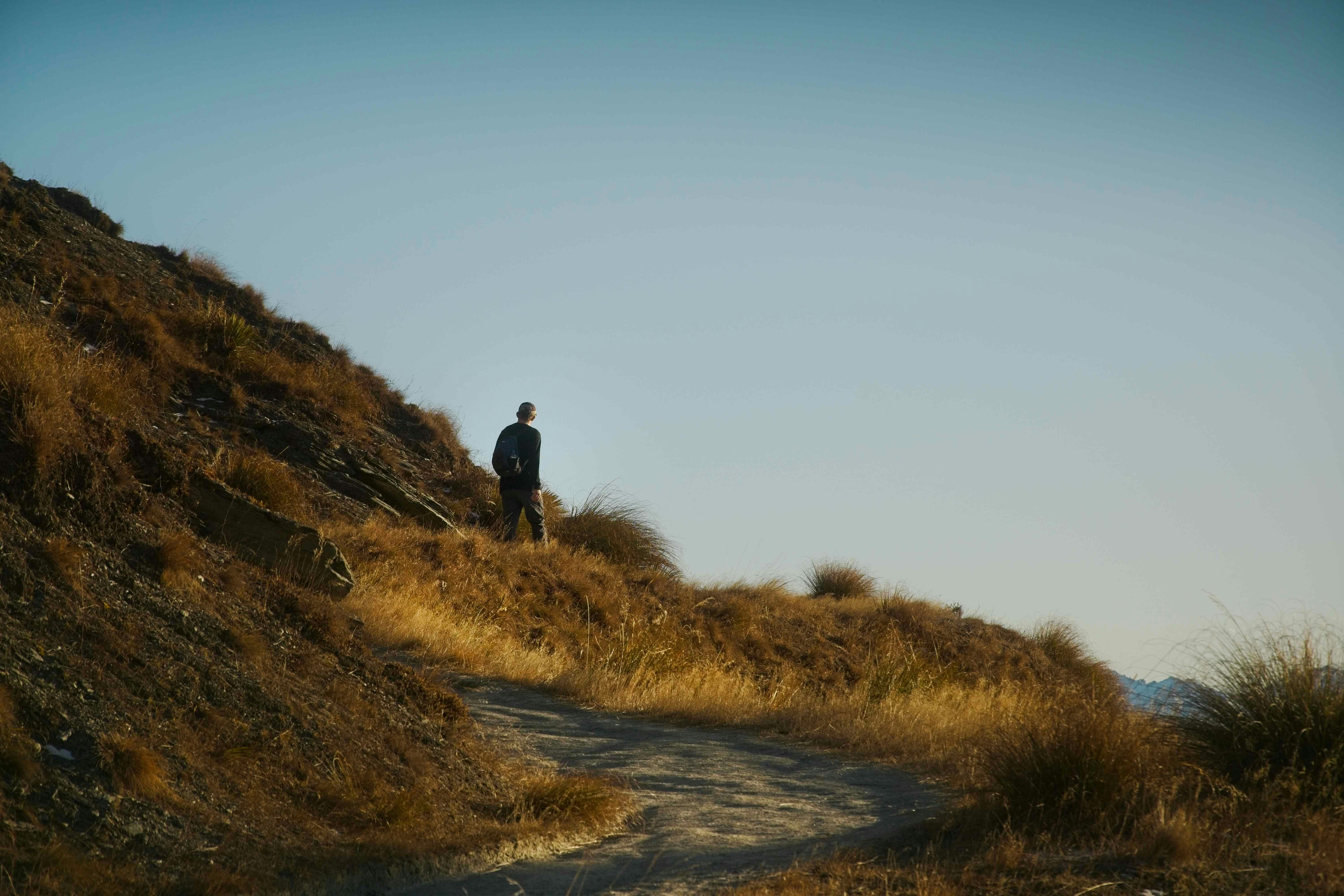 a man standing on top of a grass covered hillside, 