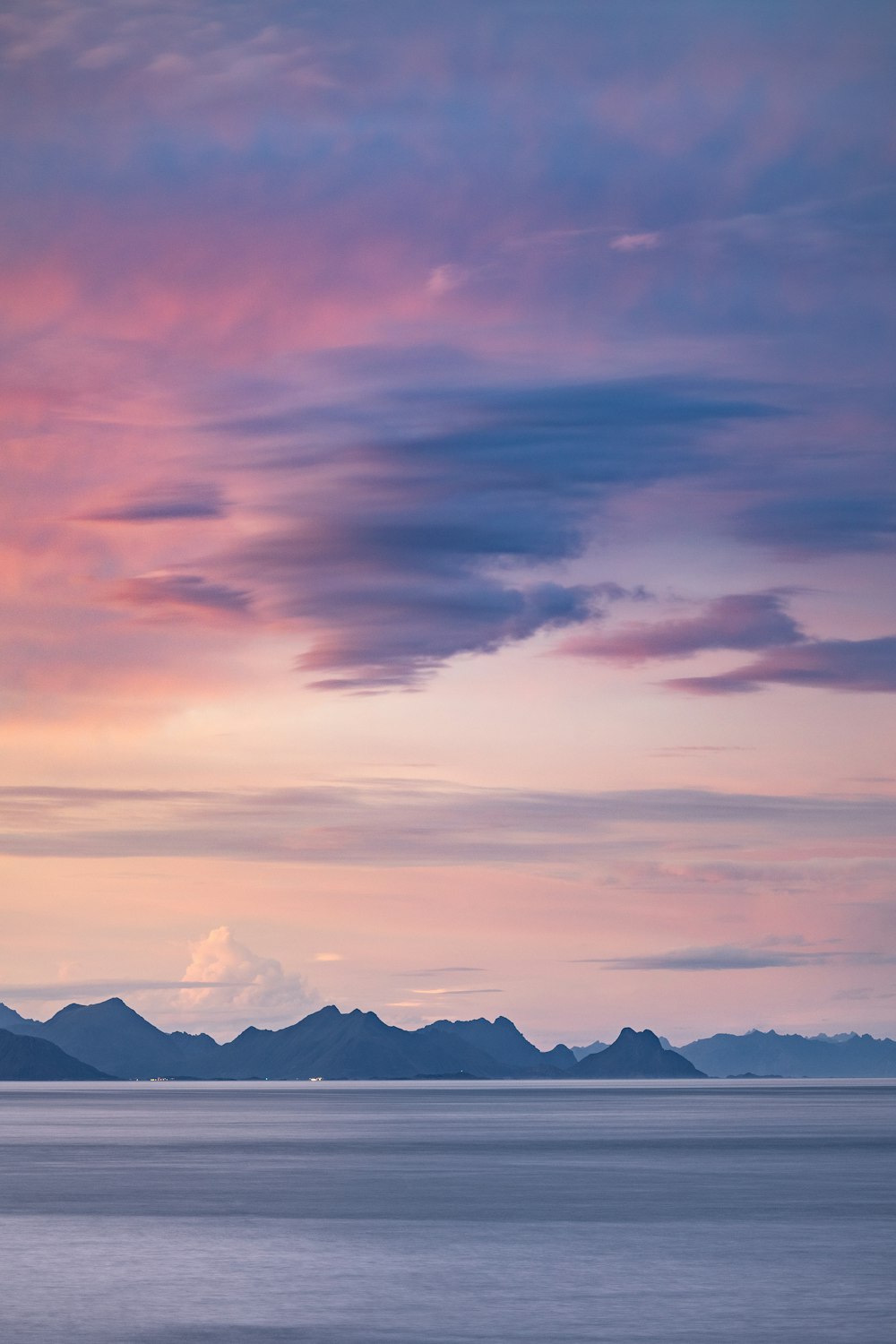 a large body of water with mountains in the background