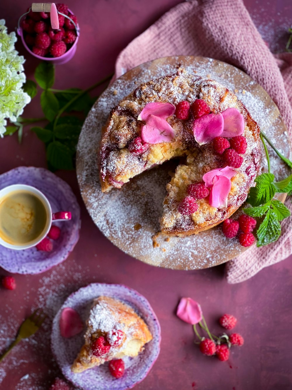 a cake with raspberries and powdered sugar on it