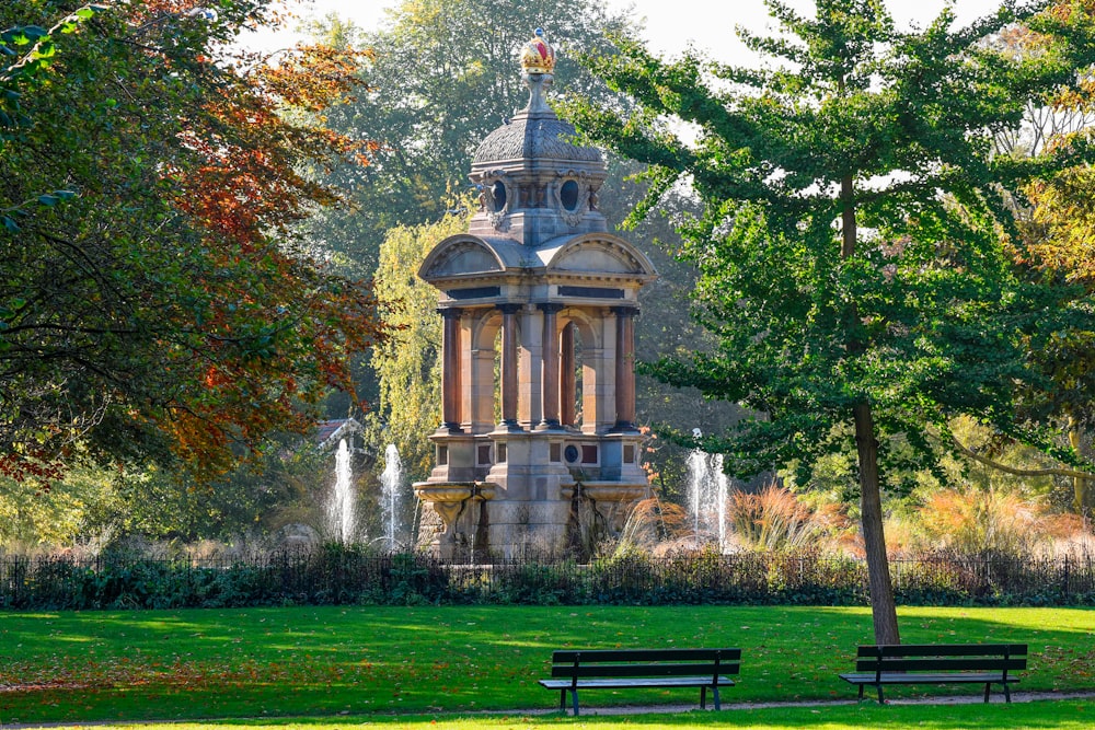 a park with a fountain and trees in the background