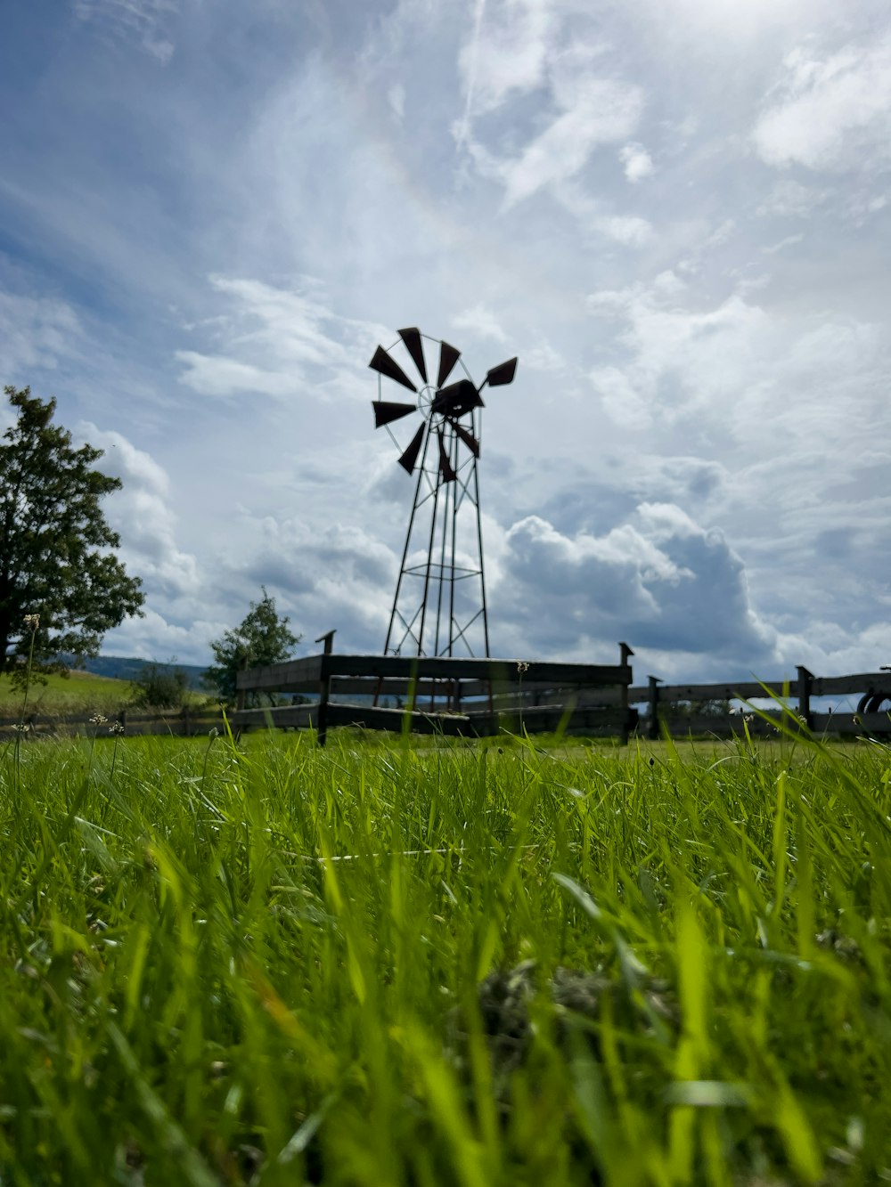 a windmill sitting in the middle of a lush green field