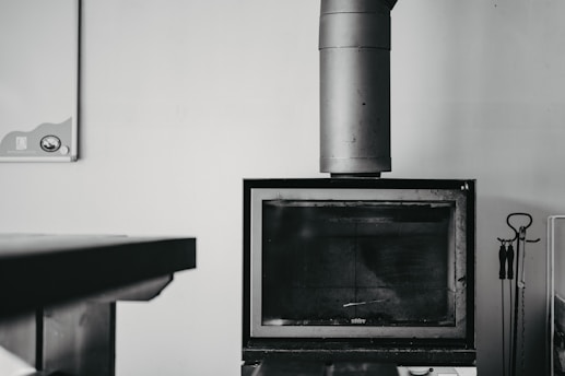 Close-up of a professional chimney sweep at work on a rustic fireplace.