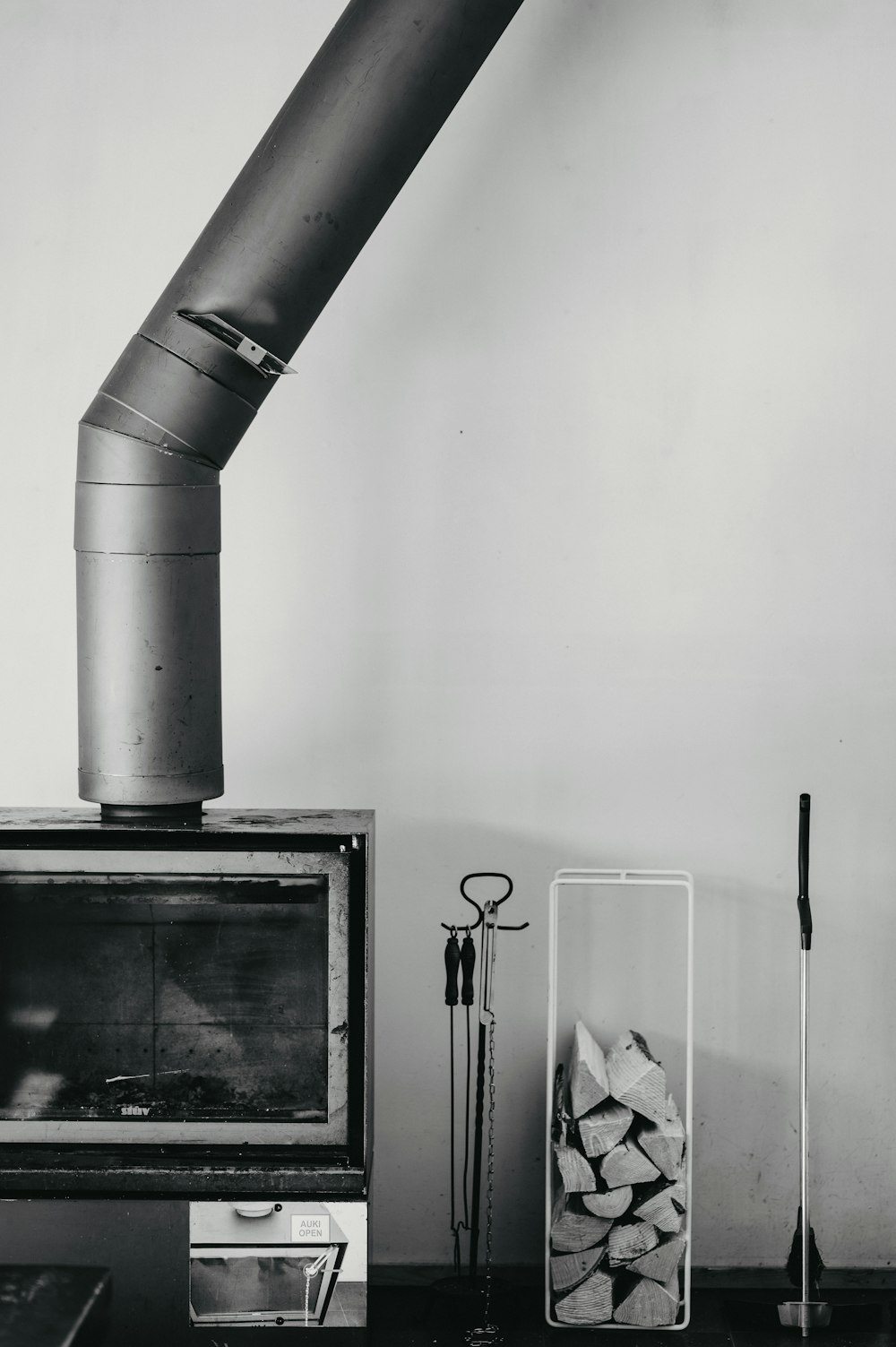 a black and white photo of a stove and a stack of logs