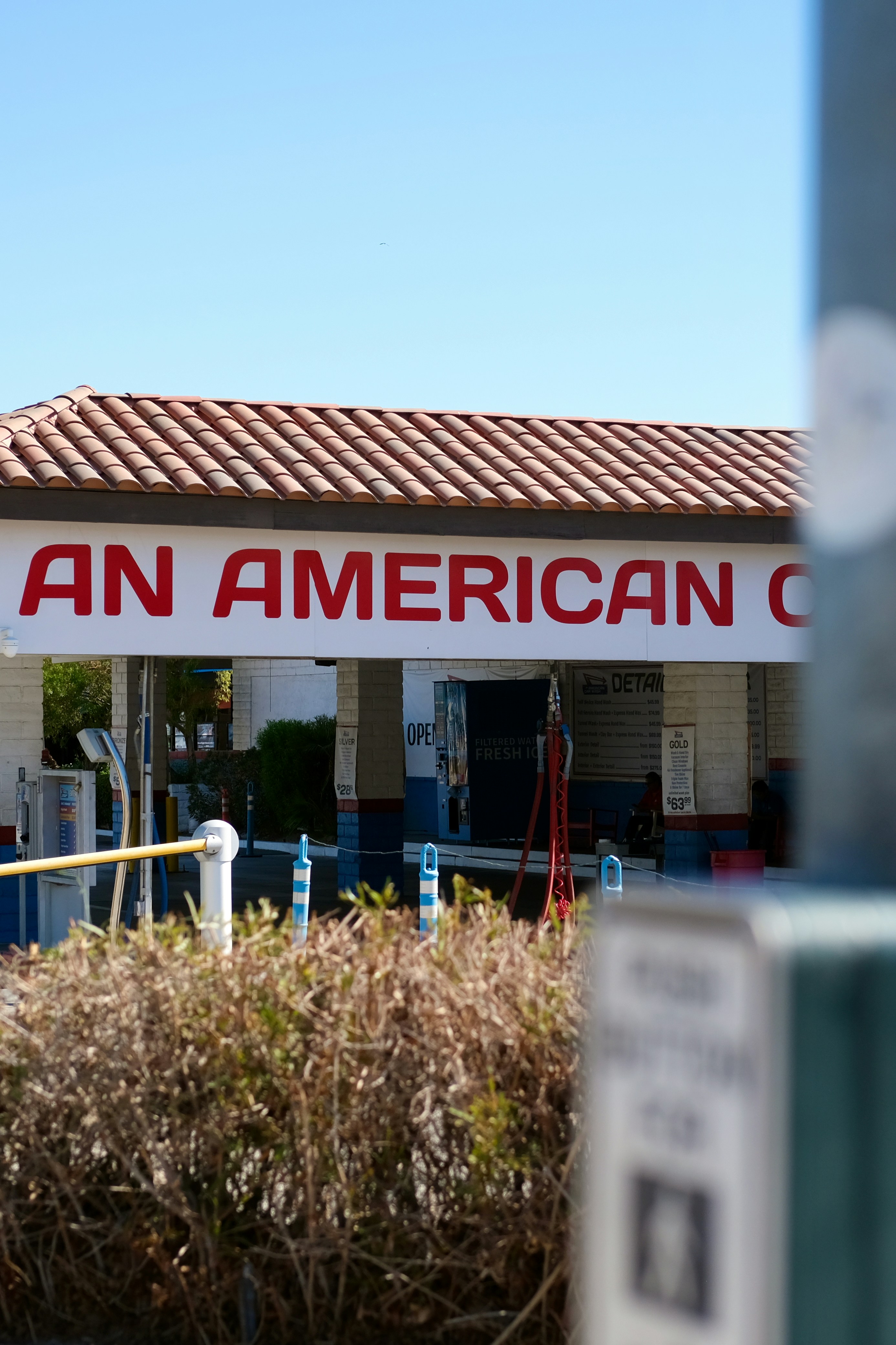 an american gas station with a red and white sign