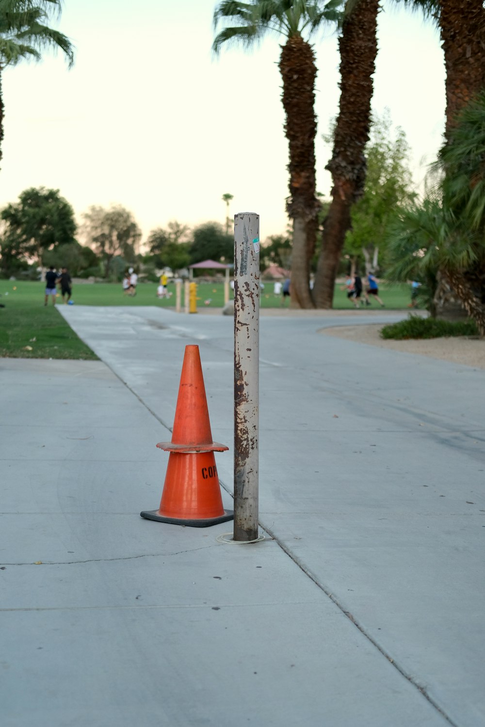 an orange traffic cone sitting on the side of a road