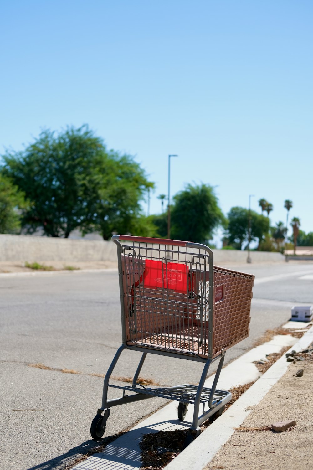 a shopping cart sitting on the side of a road